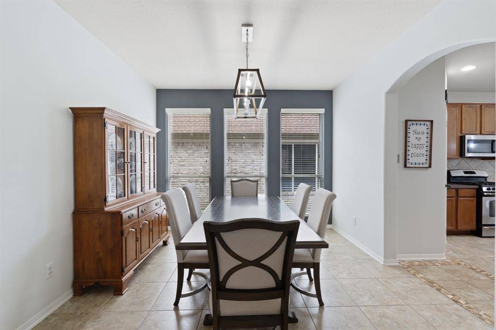 Nestled between the den and the kitchen, the formal dining space is filled with natural light—an ideal setting for family dinners or hosting guests.