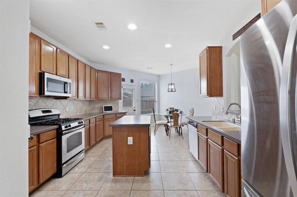 Spacious and functional, the kitchen offers plenty of counter space, stainless steel appliances, and a central island—ideal for prep, serving, or casual conversation.