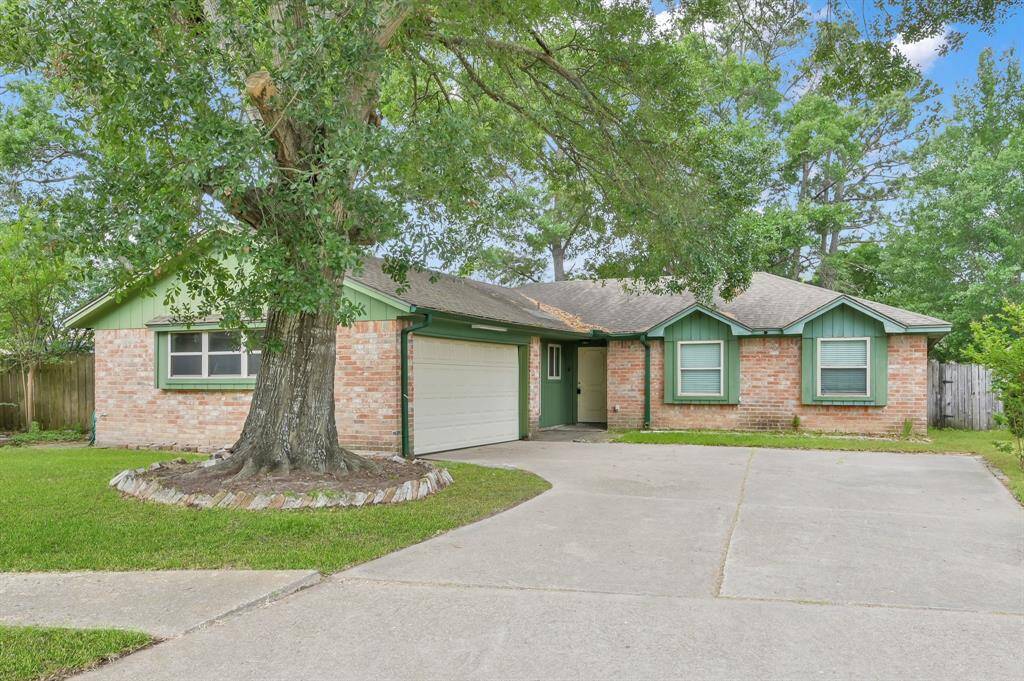 Wonderful family home the massive with a massive oak tree showcasing the front yard.