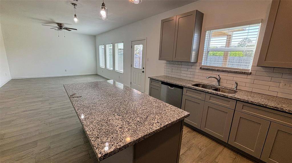 This modern kitchen features granite countertops, ample cabinet space, and a central island.
