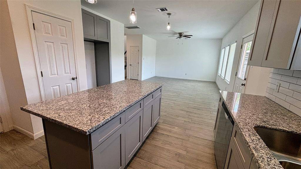This modern kitchen features granite countertops, ample cabinet space, and a central island