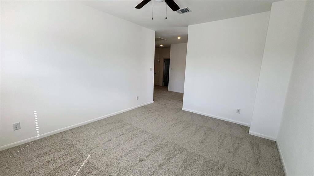 View from the game room leading to the hallway with neutral carpeted flooring. There is a doorway leading to another area.