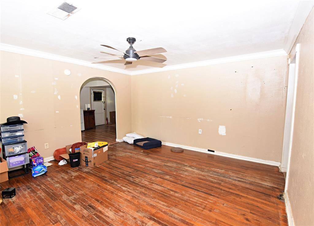 A spacious and cozy living area that flows seamlessly into the kitchen and dining combo through a charming arched opening