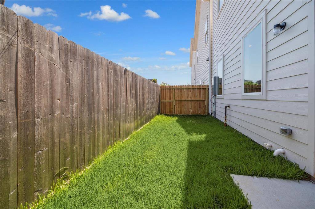 Private fenced backyard with a grassy area—ideal for pets, small gatherings, or enjoying a bit of outdoor relaxation in a low-maintenance space.