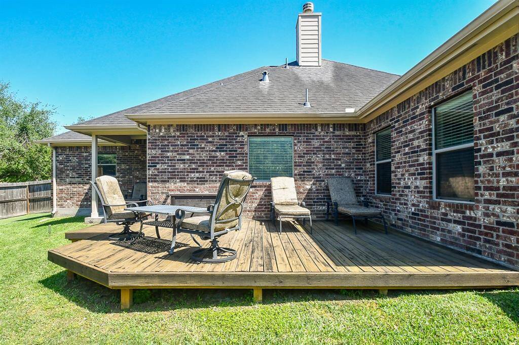 There is a lovely backyard with a deck.