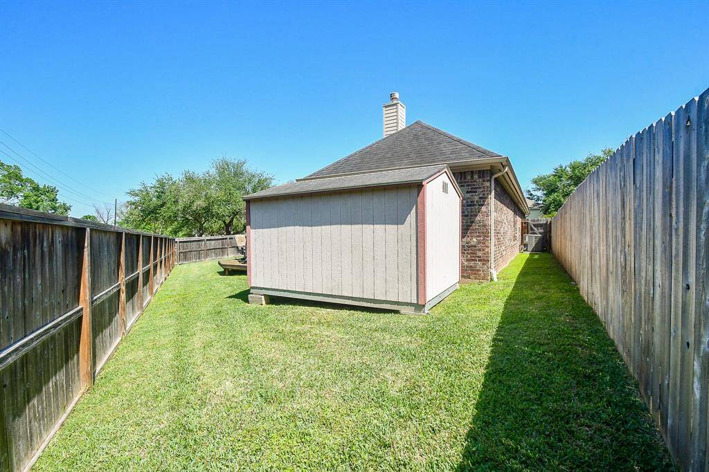 A sturdy 8x12x8 ft Tough Shed in the backyard is securely anchored to the ground.