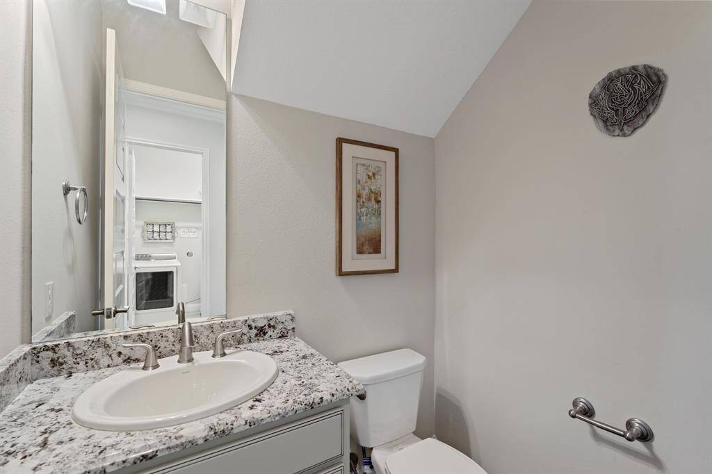 Half bathroom for guests is near the stairs and across from the laundry room.
