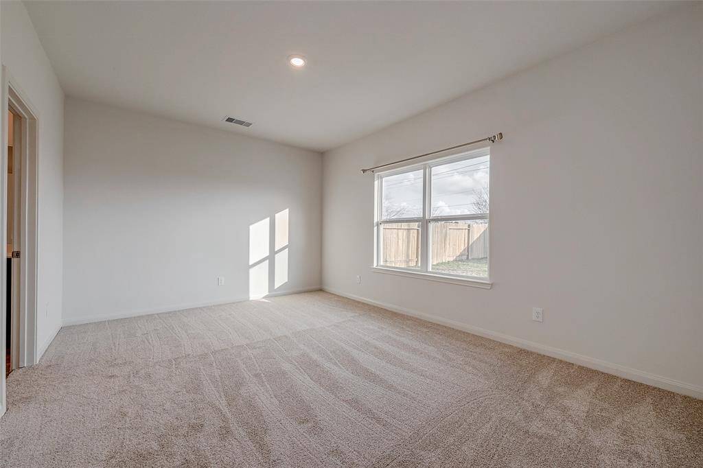 The primary bedroom is freshly painted with new carpet.  The window overlooks the backyard.