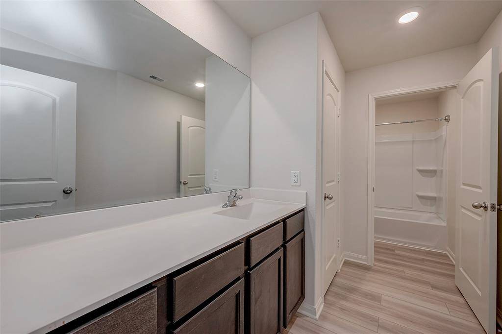 Secondary bathroom shared by the 4 bedrooms upstairs features a shower/tub combo, linen closet, and large vanity space.
