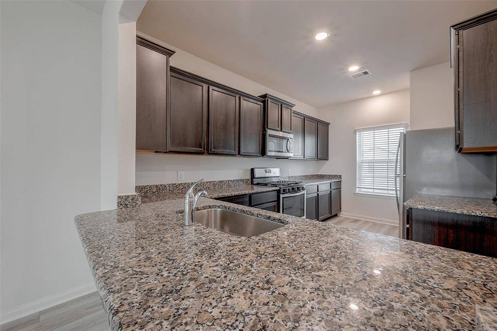 Sleek finishes such as dark stained cabinets, granite countertops, and stainless steel appliances make cleaning easy!