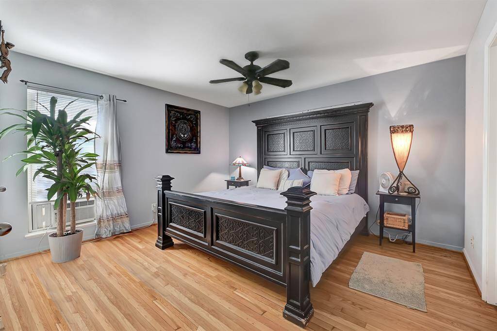 This bedroom features a cozy atmosphere with light blue walls and warm wood flooring.