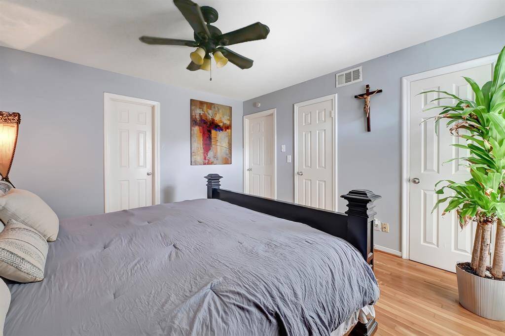 This bedroom features a cozy atmosphere with light blue walls and warm wood flooring.