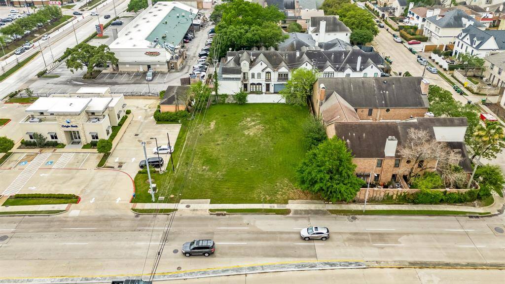 This aerial photo showcases a vacant lot situated between two buildings in a developed urban area. It offers potential for construction and is conveniently located near commercial establishments and residential neighborhoods, providing easy access to amenities and main roads.