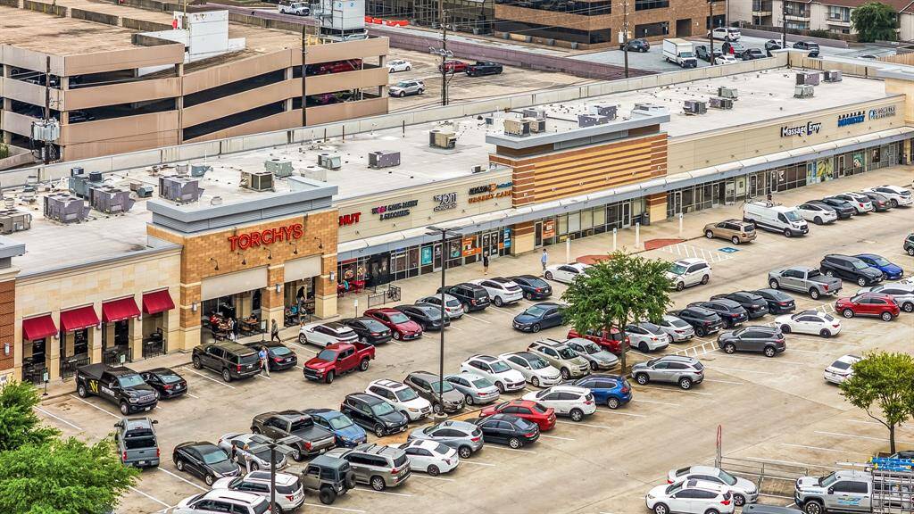 This photo shows a bustling retail strip center with multiple businesses, ample parking, and convenient access. Ideal for home buyers looking for nearby shopping and dining options.