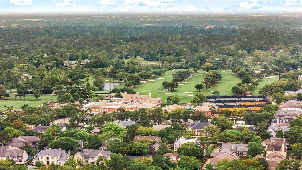 This photo showcases a vibrant, lush neighborhood with nearby homes, bordered by a scenic golf course and abundant greenery, offering a serene and upscale living environment.