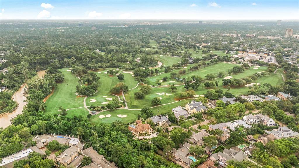 This photo showcases a luxurious residential area adjacent to a sprawling golf course, surrounded by lush greenery. Ideal for buyers looking for a serene environment with recreational amenities and upscale homes.