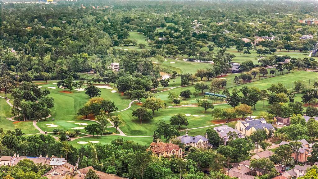 This photo showcases a picturesque view of a lush, green golf course surrounded by residential homes. The expansive greenery and trees provide a serene and upscale neighborhood setting, ideal for golf enthusiasts and those seeking a tranquil environment.