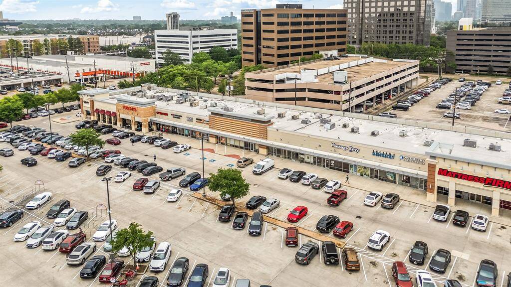 This aerial photo showcases a bustling commercial area with a variety of businesses, ample parking, and nearby residential homes. Ideal for buyers seeking convenience and access to amenities.