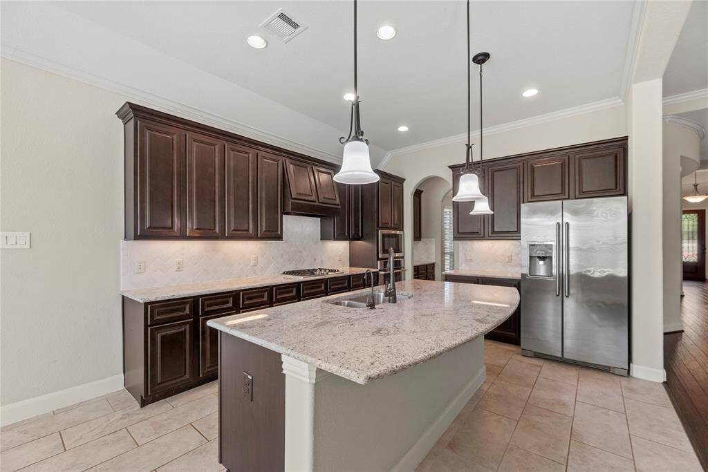 Granite countertops paired with a coordinating stone backsplash not only provide a durable and elegant surface for food preparation but also add a touch of luxury and sophistication to the kitchen.