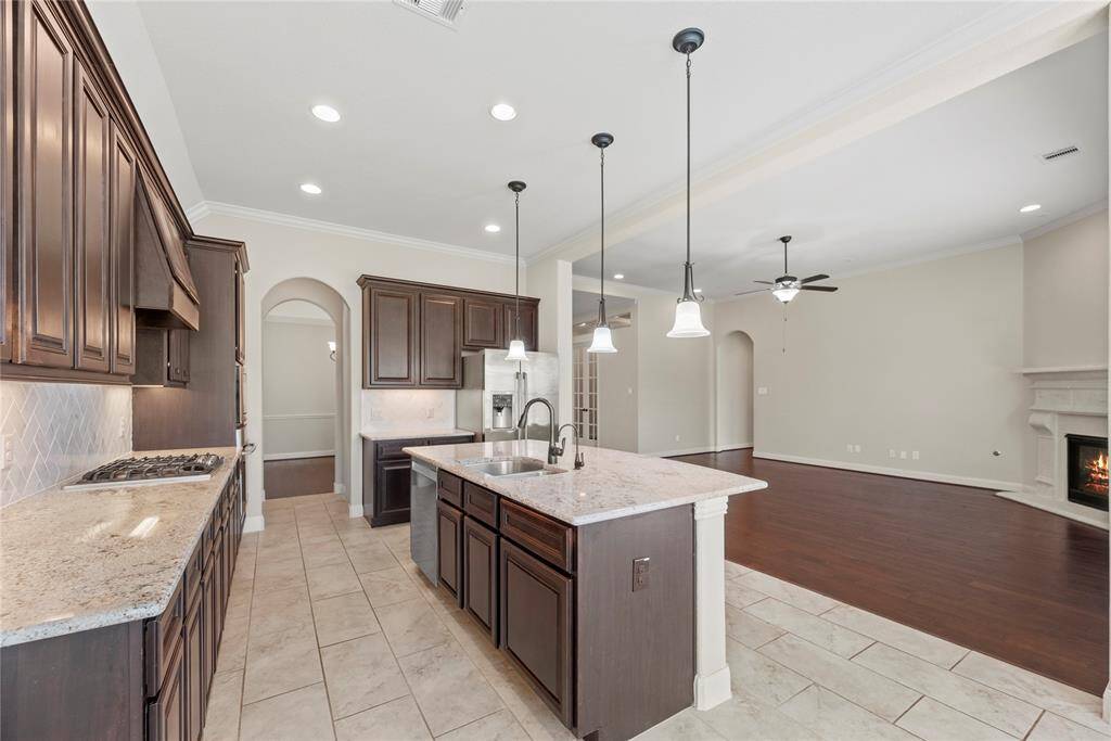 The sprawling island with breakfast bar seating serves as a versatile centerpiece, providing additional workspace, storage, and seating for casual dining or entertaining.