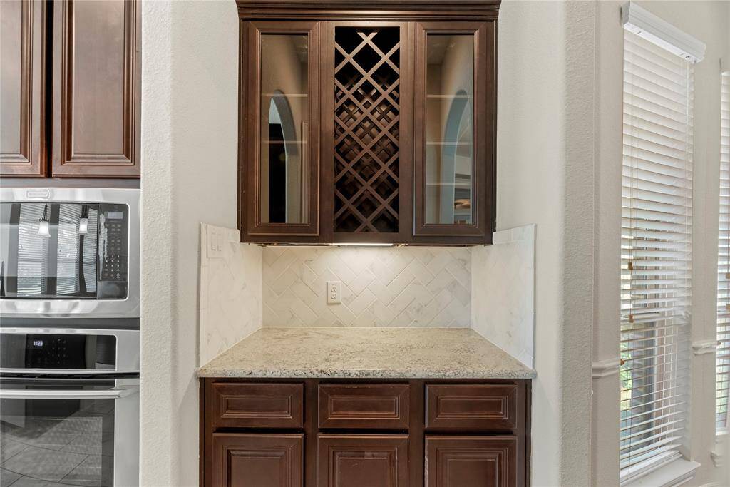 The butler's pantry provides access to the formal dining room and features Granite counters, coordinating cabinets, and glass overhead cabinets to display your favorite stemware.