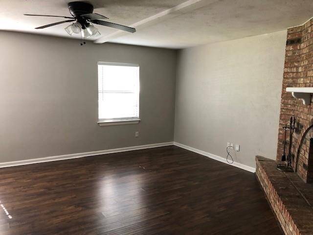 Large den with corner fireplace, new plank flooring and mini-blinds