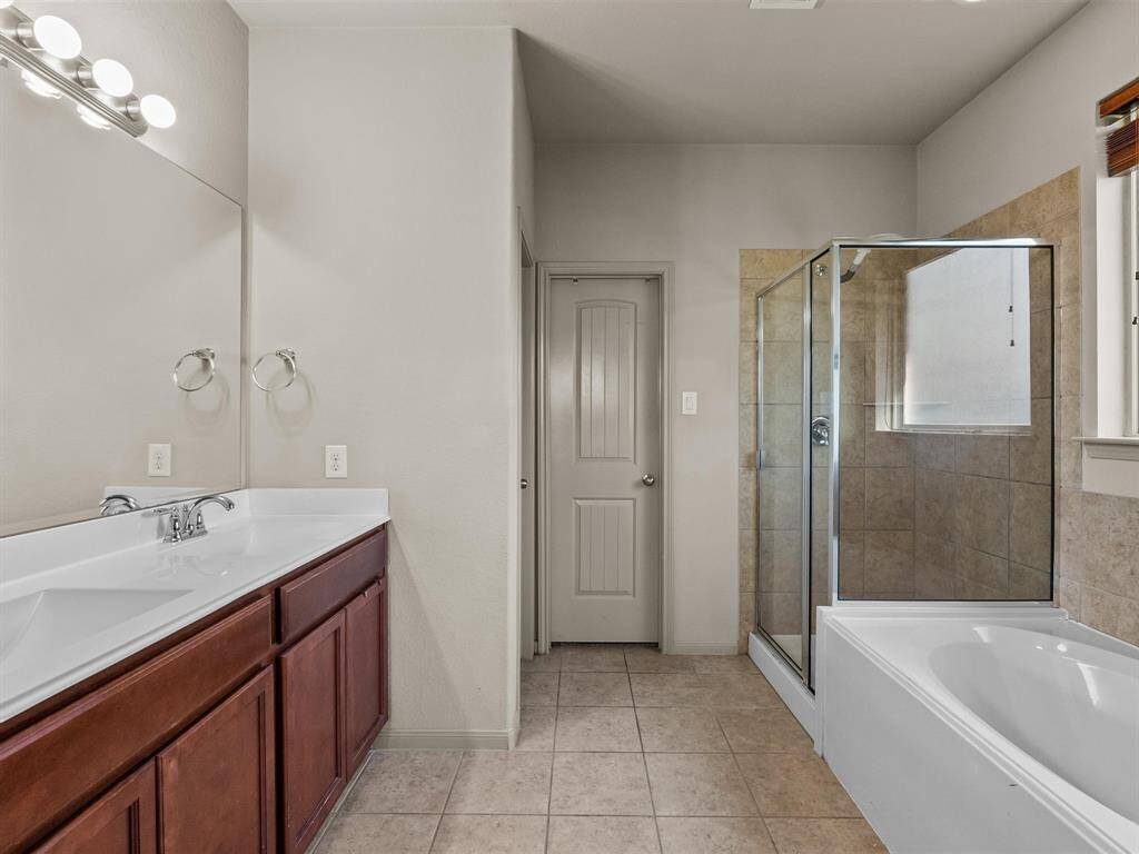 The oversize primary bath features double sinks, soaking tub, separate shower, and walk-in closset.