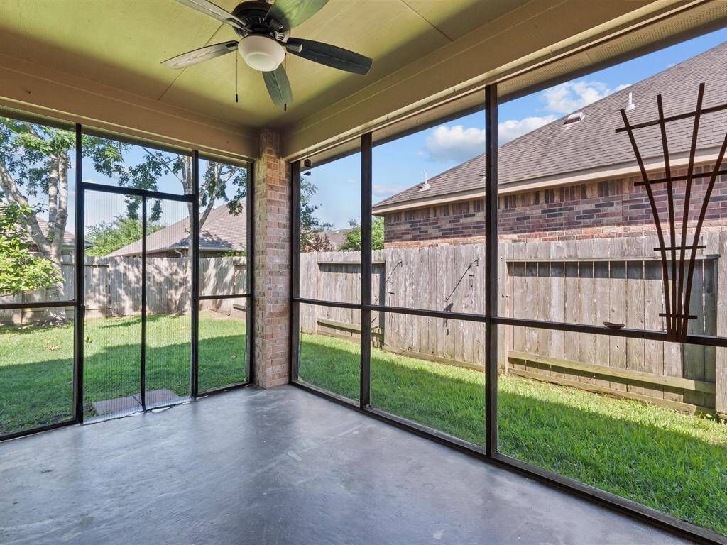 Ahhhhh... relax in the screened porch, complete with ceiling fan and backyard access.