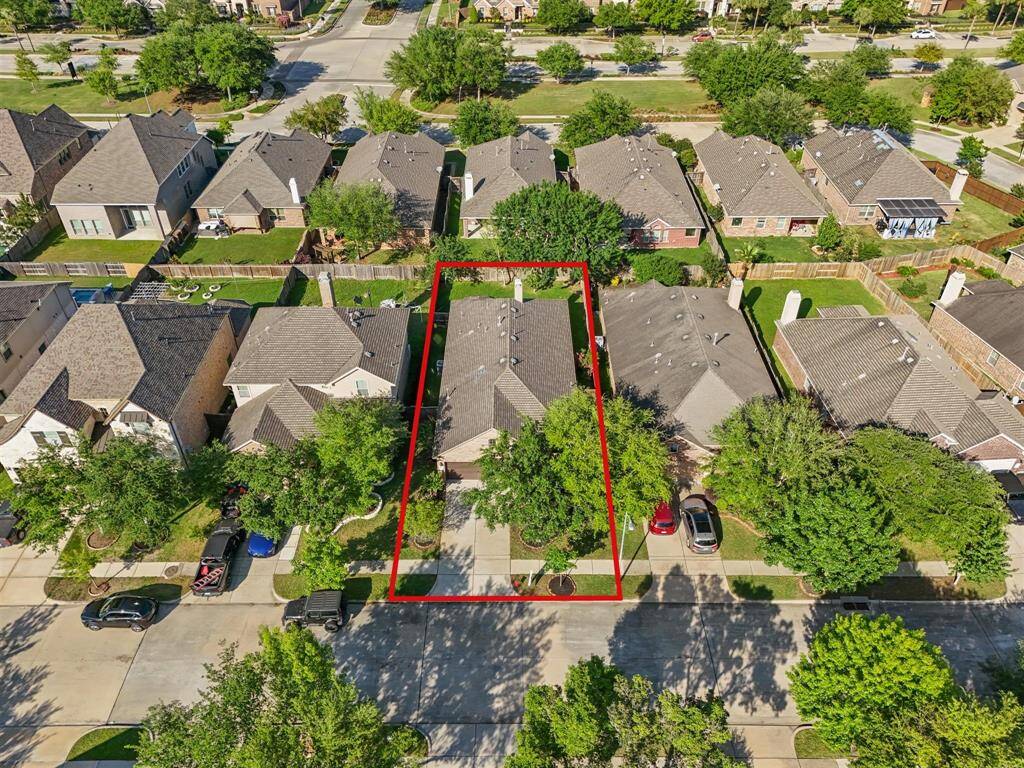 An aerial view of the home with its lovely tree-lined street.