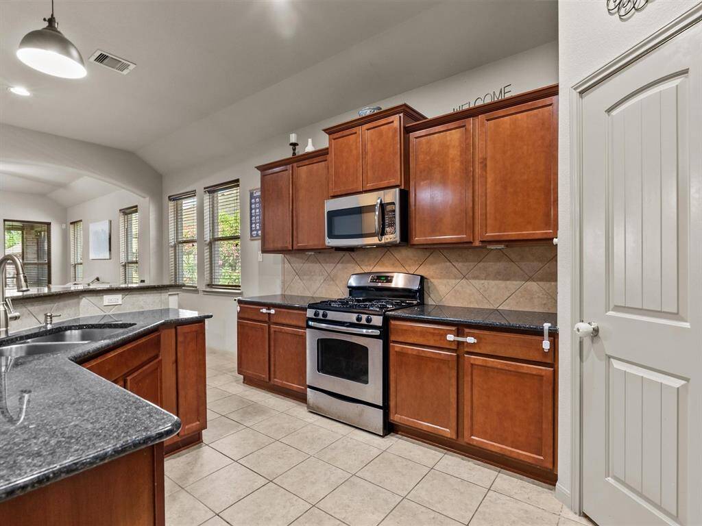 The rich wood cabinetry & granite counters create a classic profile.