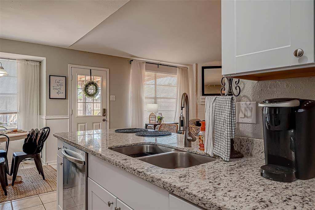 The kitchen is open to the living room and has stainless steel appliances, newer shaker-style cabinets and granite counter tops!