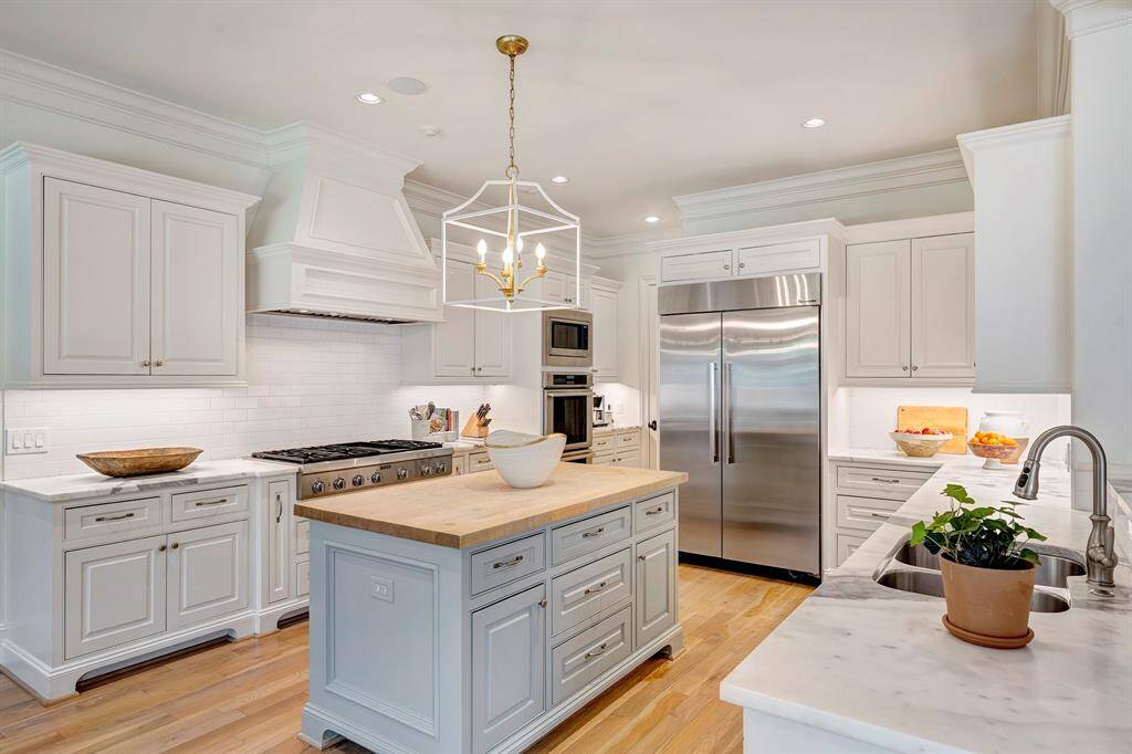 Chef's kitchen offers high-end stainless steel appliances, including a large gas cooktop and double ovens.