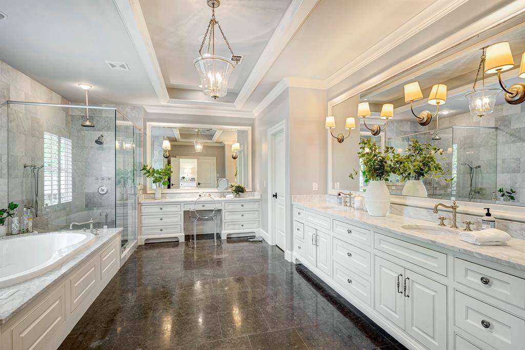 Luxurious primary bath boasts a spacious shower, separate tub, dual sinks, and a vanity area.