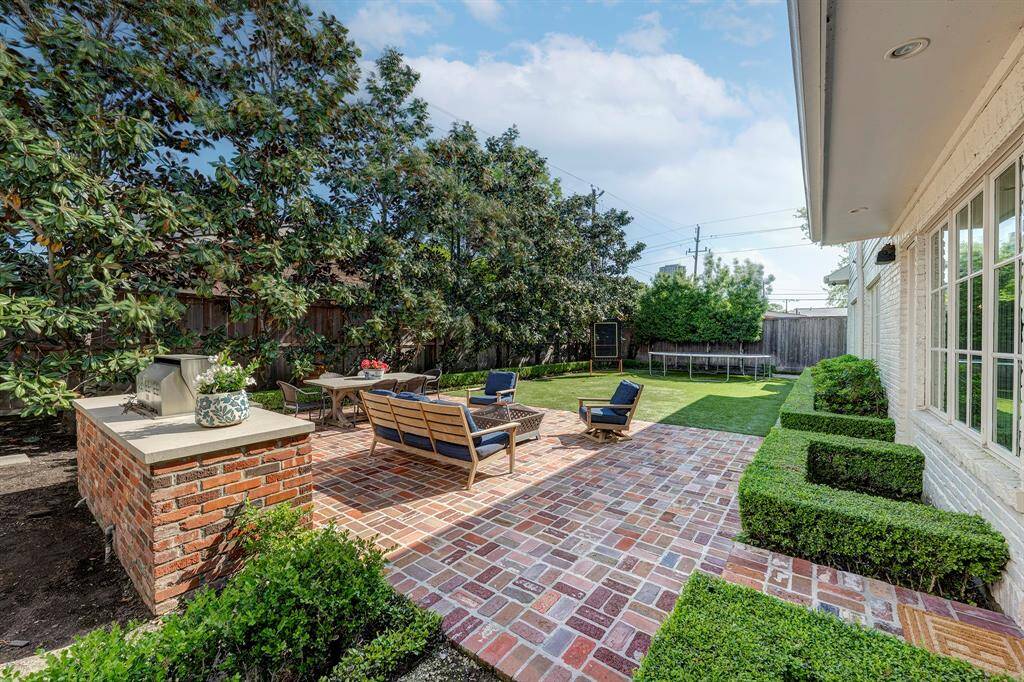 Spacious brick patio with ample room for both outdoor seating and dining areas.