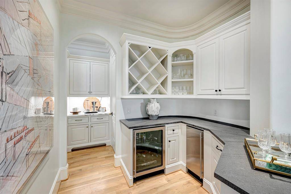 The butler's pantry provides extra storage, a wine fridge, and elegant display shelves for glassware.