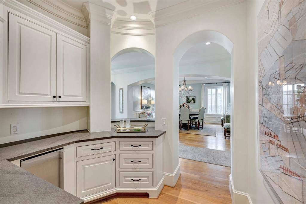 View from the butler's pantry towards the dining room, showcasing the arched openings, crown molding, and high ceilings.