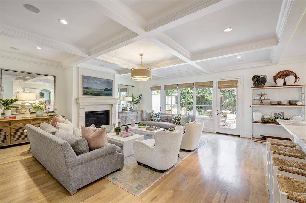 Inviting family room featuring a fireplace and stunning coffered ceiling is open to the kitchen. Door leads to patio and backyard.