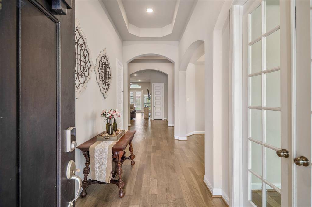 Welcome home! This stunning 1.5-story residence offers eye-catching curb appeal with a clean, modern stucco exterior, charming architectural details, and a beautifully manicured lawn. Enjoy the convenience of a spacious three-car garage and a wide driveway—perfect for multiple vehicles or extra storage. Thoughtful accents like iron scrollwork and soft exterior lighting enhance the home’s timeless elegance.