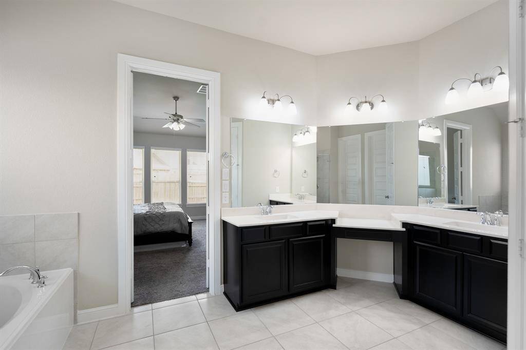 Step into comfort and style in this beautiful primary bathroom! Featuring dual sinks, quartz countertops, large mirrors, and a make-up vanity.