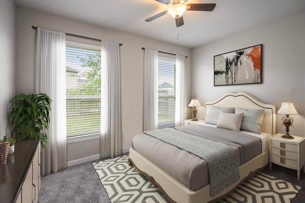 Bright and inviting, this spacious secondary bedroom offers plenty of room for relaxation and personalization, making it the perfect retreat for family or guests. It features plush carpet, bright natural light, and a ceiling fan.