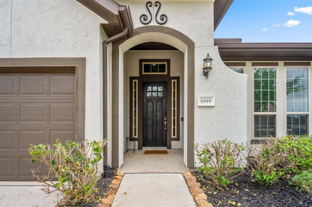 The inviting front entryway features a tall, elegant door framed by transom windows, creating a warm and welcoming first impression.