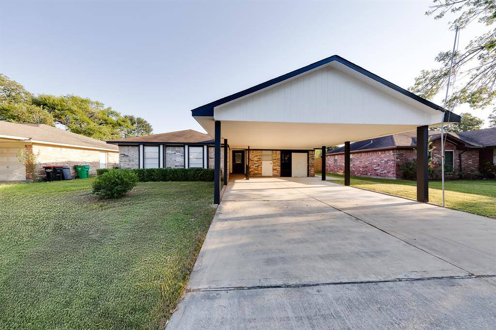 The front of this charming home features a long, covered double-wide driveway, providing plenty of parking. With a lovely brick exterior and a generous yard, it exudes curb appeal and welcomes you with a warm, inviting presence