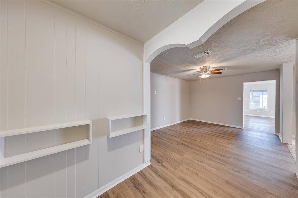 This stunning entryway makes a striking first impression, featuring elegant built- in shelving that adds both style and functionality. Conveniently located just steps from the dining area, it sets the tone for a warm and welcoming home.