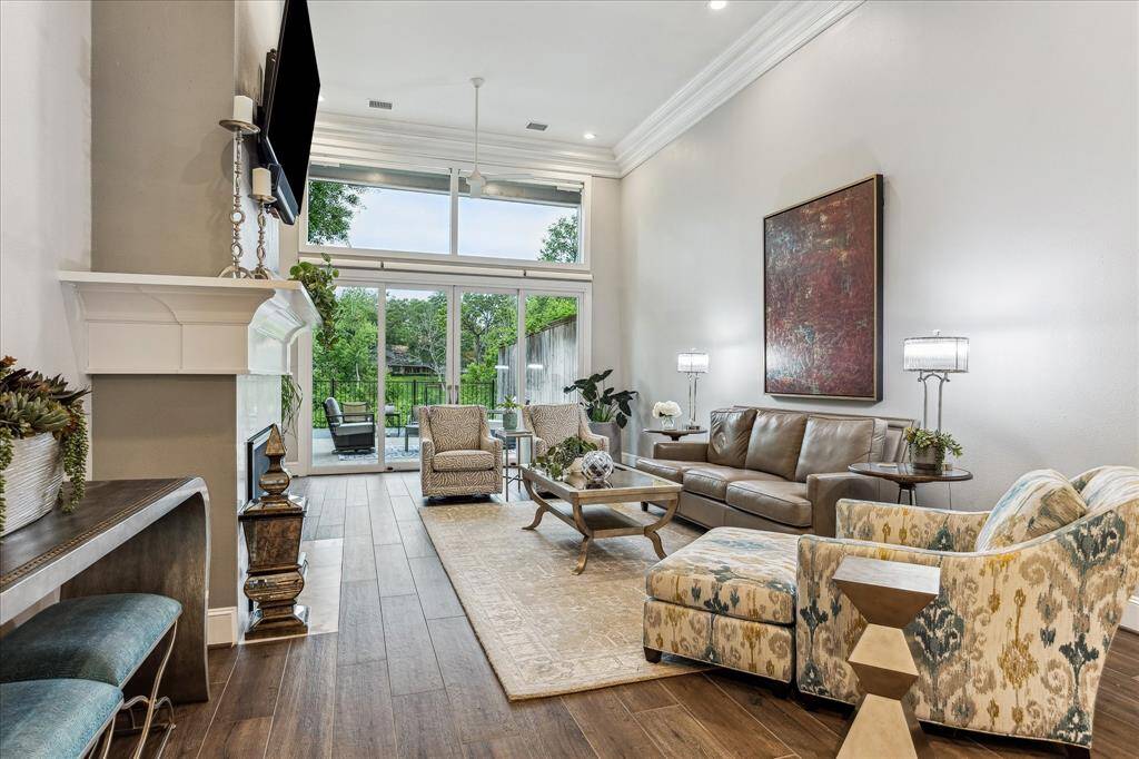 The living area boasts high ceilings, a sleek fireplace, and elegant crown molding, creating a spacious room.