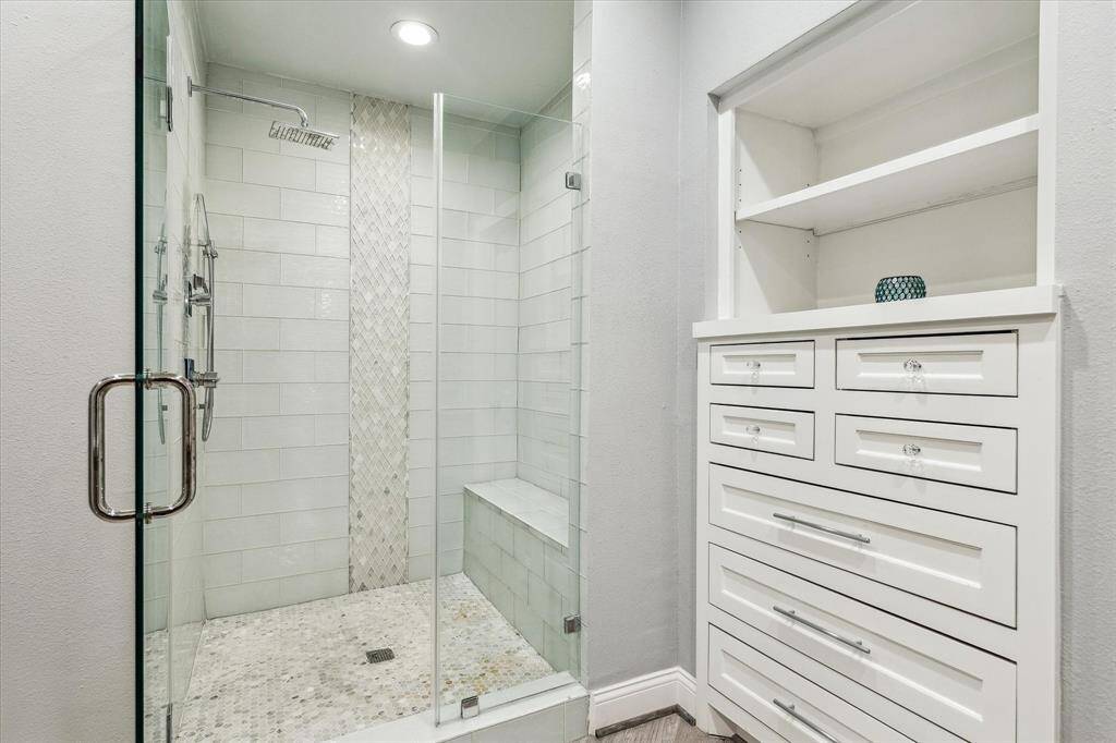 The glass framed shower with a rainfall showerhead and built-in seat. The thoughtful design creates a spa-like retreat perfect for relaxation.