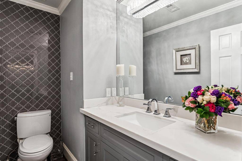 Stylish powder room with a floating vanity and tiled wall.