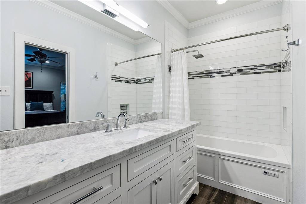 The en-suite bathroom that has been beautifully renovated with a soaking tub and shower, custom cabinetry, and marble countertop.