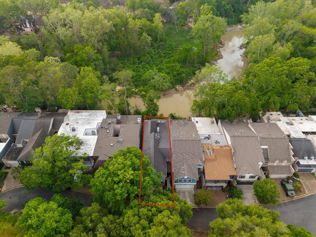 From the aerial view, you can truly appreciate the home's prime location, surrounded by lush greenery and offering serene views of the nearby Buffalo Bayou.