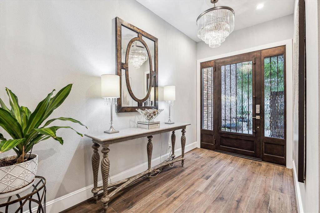 Warm tones enhance the open layout and a striking glass-paneled door welcomes you in, all beautifully illuminated by a statement chandelier. Easy maintenance wood-look tile flows throughout the first floor.
