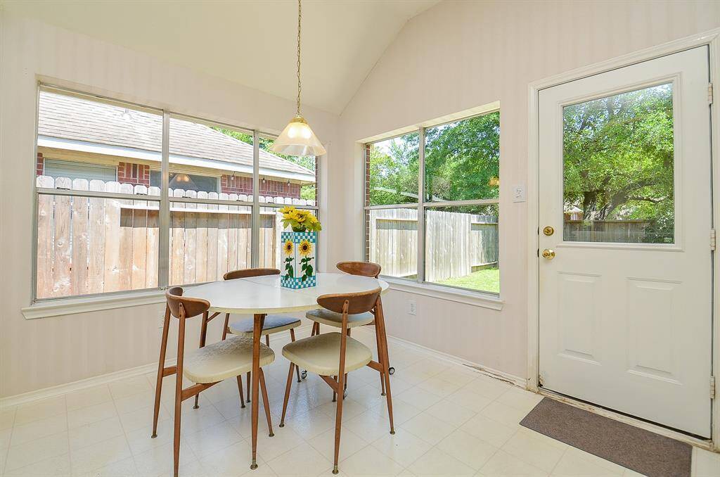 Bright breakfast area with large windows offering outdoor views and easy access to the outdoor space.
